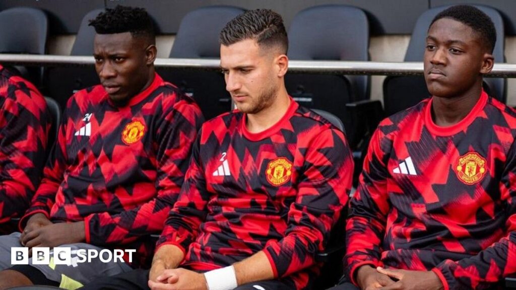 Manchester United midfielder Kobbie Mainoo and goalkeeper Andre Onana sitting on the bench at Fulham