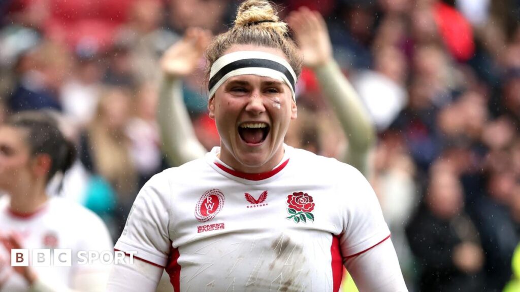 Boxer Ricky Hatton applauds fans while wearing a gold gown in the ring